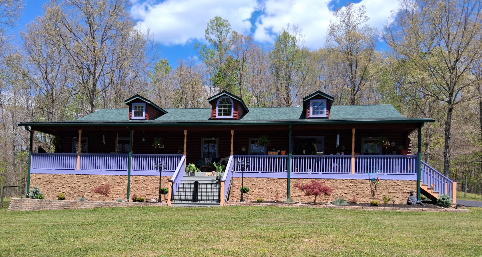 log cabin home with premium landscaping with low retaining wall and designer plants with multi texture in greater beckley wv
